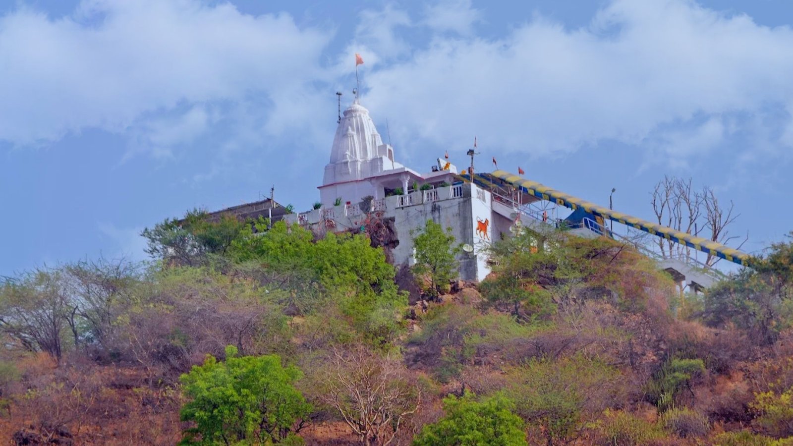 Neemach Mata Temple perched atop a green hill in Udaipur, overlooking Fateh Sagar Lake with panoramic views and forested trails.
