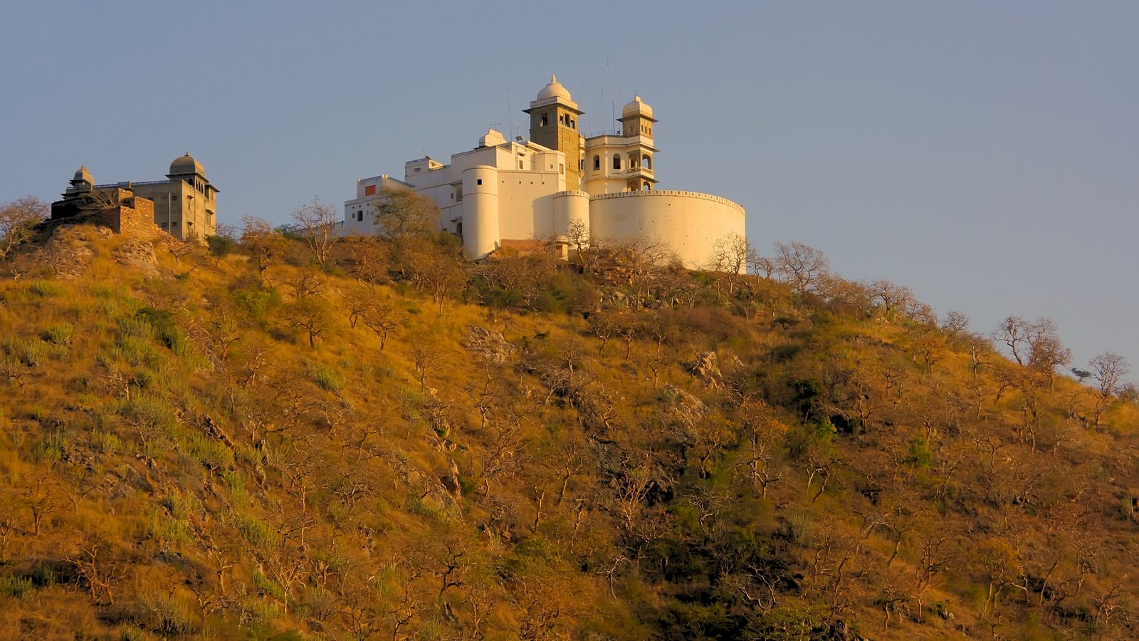 Hilltop view of Sajjangarh Fort in Udaipur, bathed in golden light and overlooking the Aravalli ranges
