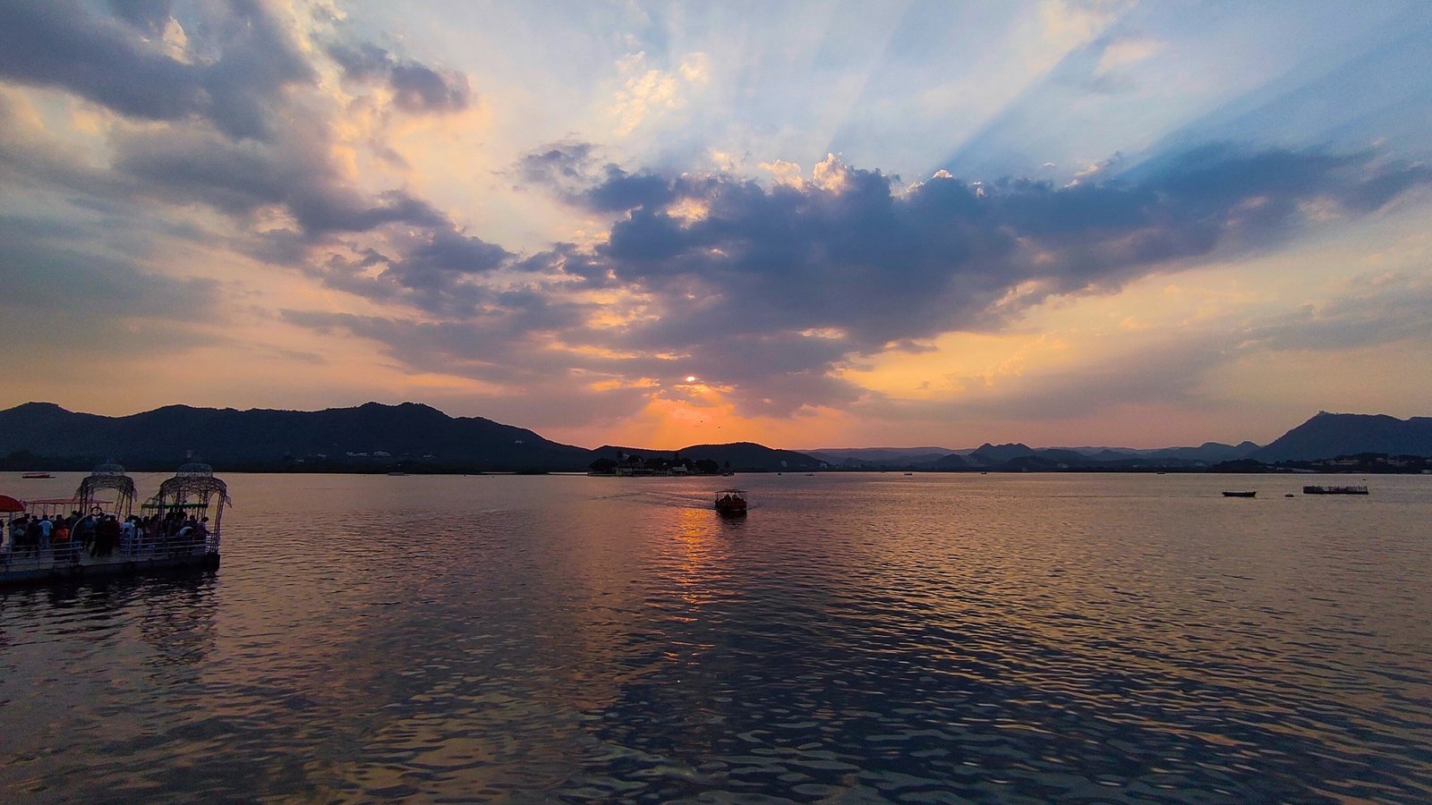 2 City Palace in Udaipur illuminated at twilight, showcasing its majestic domes and lakeside architecture