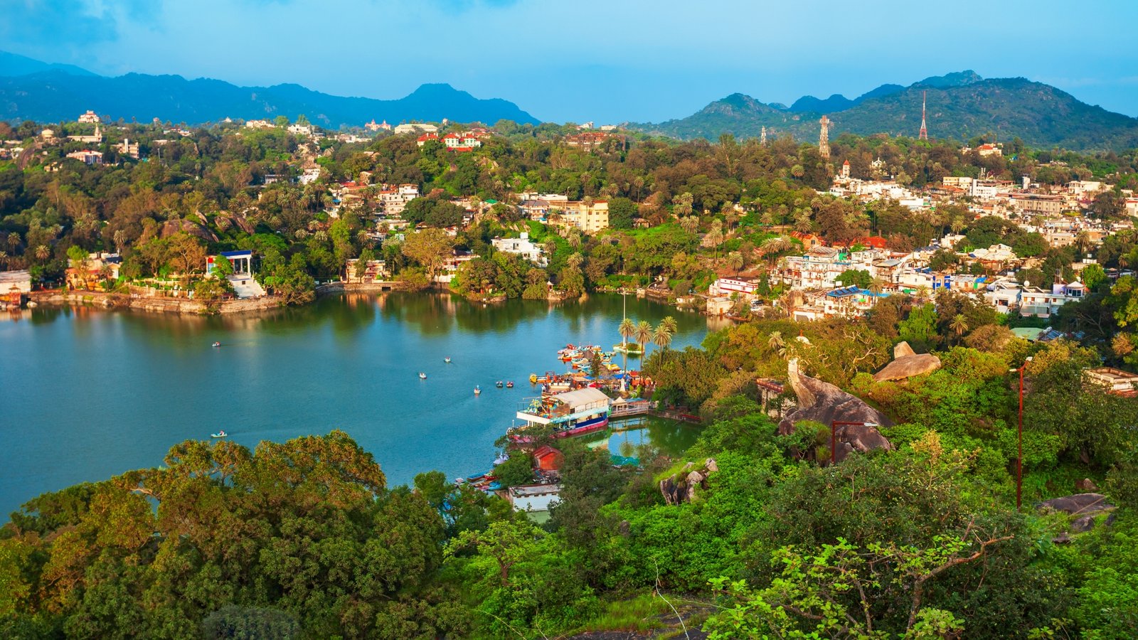 Scenic view of Mount Abu hill station in Rajasthan, with lush greenery, rocky cliffs, and Nakki Lake nestled among the Aravalli hills.